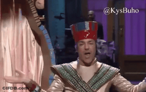 Costumed Man With Red Hat And Purple Wall GIF