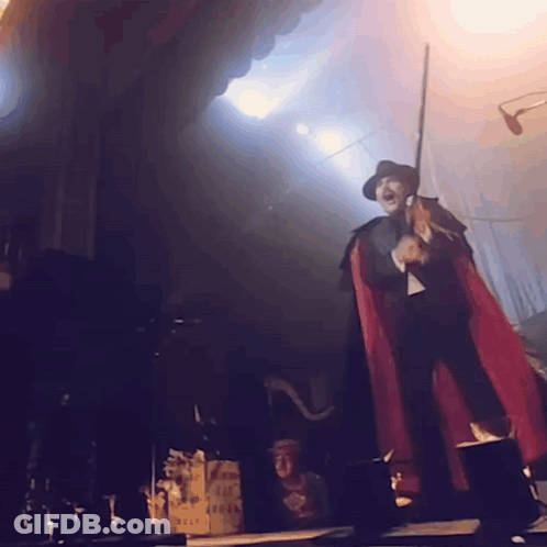 Costumed Person With Eye On Head On Stage GIF