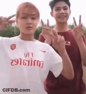 Couple Giving Peace Signs, Woman In Nike Shirt GIF