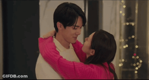 Couple Kissing In Front Of Christmas Tree GIF