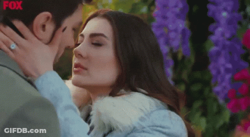 Couple Kissing In Front Of Flowers With Fox GIF