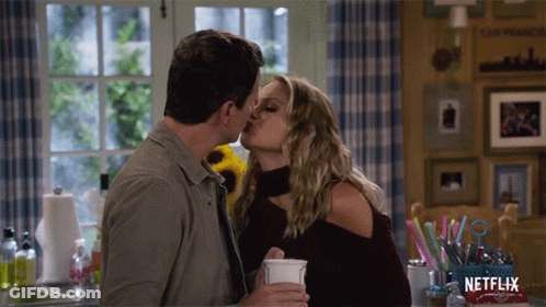 Couple Kissing In Front Of Netflix Box GIF