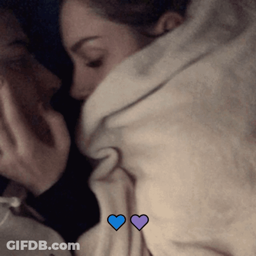 Couple Lying Under Blanket With Blue Hearts GIF
