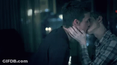 Couple Of Men Kissing In Front Of Window GIF