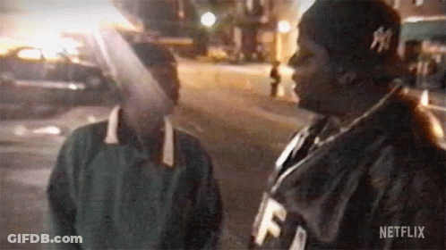 Couple Of Men Standing Next To Each Other On Street GIF