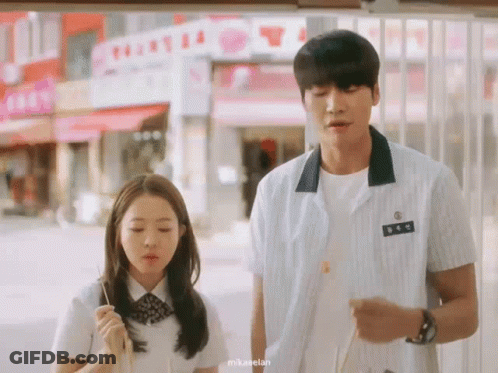 Couple Outside Building With T Sign GIF