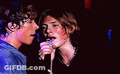 Couple Singing Into Microphones Eyes Closed GIF