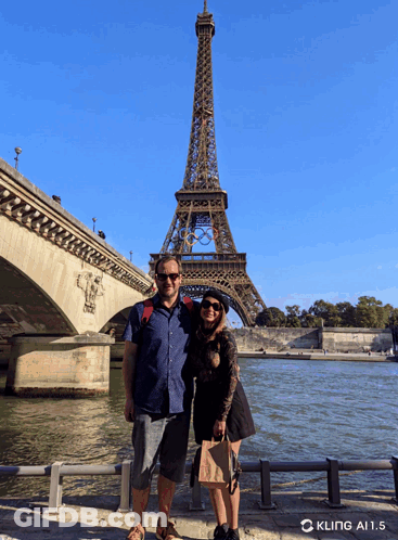 Couple Standing In Front Of Eiffel Tower GIF