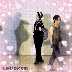 Couple Standing Together Surrounded By Hearts GIF