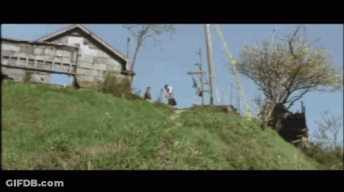 Couple Walking Down Hill In Front Of House GIF