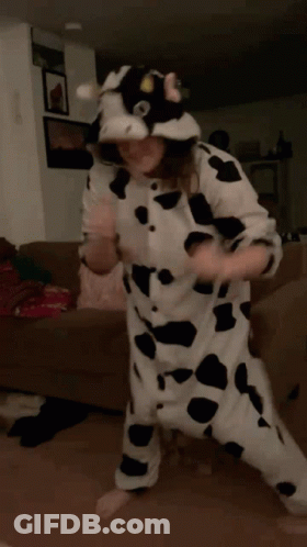 Cow Costume Person Dancing On Brown Couch GIF