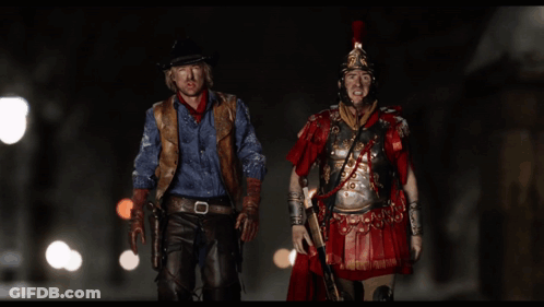 Cowboy And Roman Soldier Standing Together GIF