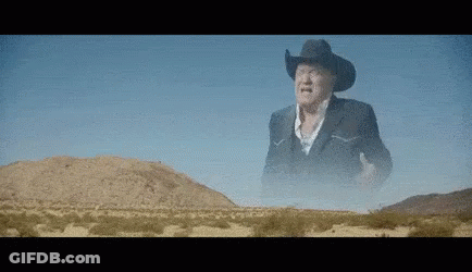 Cowboy In Desert Hands In Air GIF