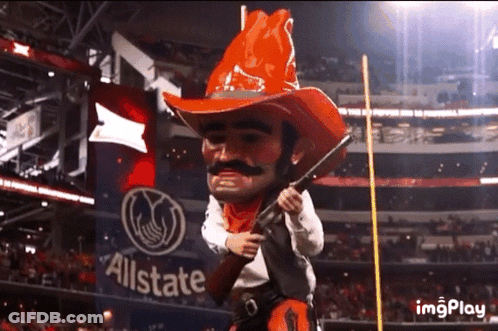 Cowboy Mascot Holding Gun In Front Of Allstate Banner GIF
