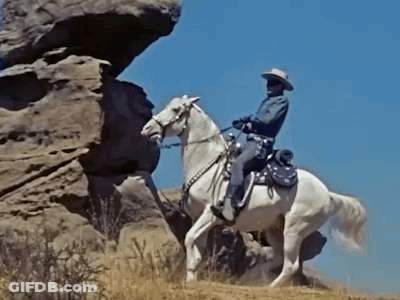 Cowboy Riding White Horse On Rock GIF