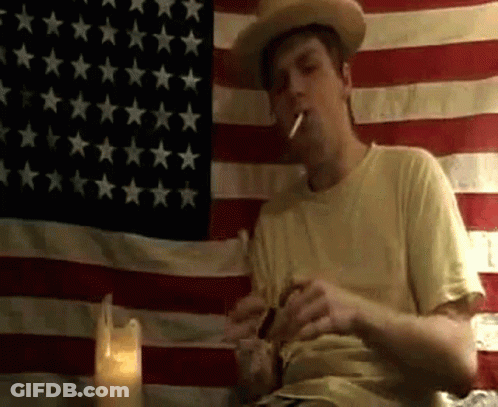 Cowboy Smoking In Front Of American Flag GIF
