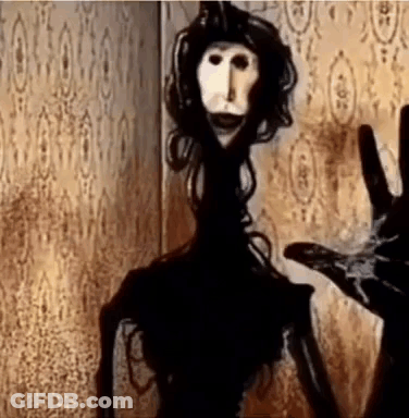 Creepy Doll Standing In Dark Room GIF
