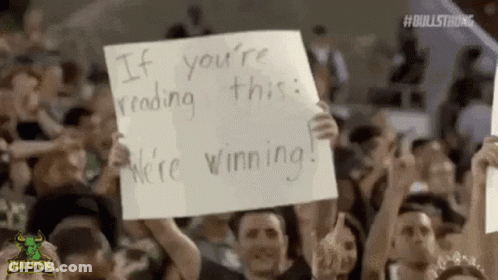 Crowd Holding Signs Saying If You're Reading This We're Winning GIF