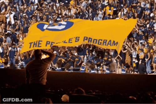 Crowd Holding Yellow Banner Saying The Peace Program GIF