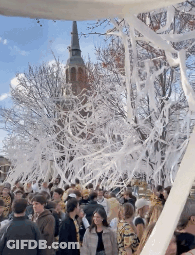 Crowd In Front Of Tower Covered In Tissue Paper GIF