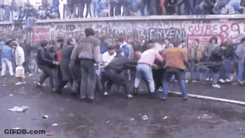 Crowd In Front Of Wall With Bienvenue Written GIF
