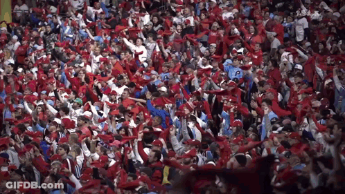 Crowd In Red Hats And Scarves With Man In Number 20 Shirt GIF