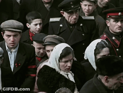 Crowd Including Woman With Scarf And Man With Hat GIF