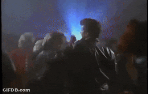 Crowd Of People Dancing In Dark Room With Blue Lights GIF