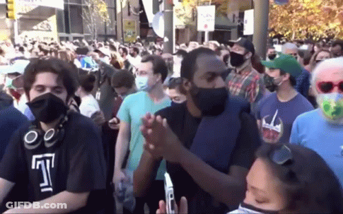 Crowd Of People Wearing Face Masks Gathered In Street GIF