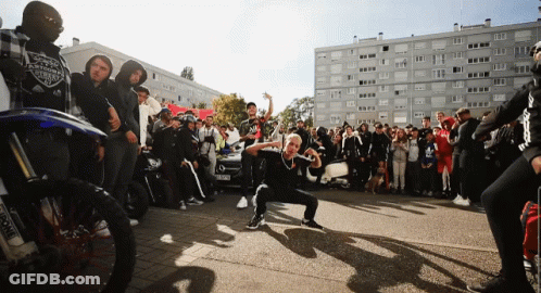 Crowd Outside Building With Harley Davidson Shirt GIF