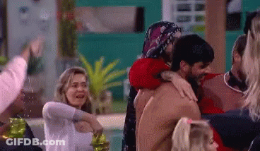 Crowd Surrounding Shirtless Man Hugged By Woman GIF