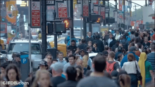Crowd Walking Down Street With No Stopping Sign GIF