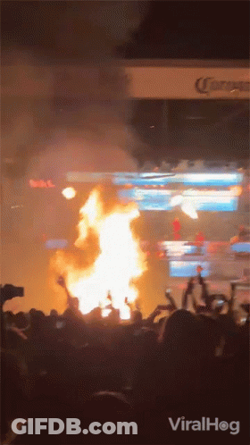 Crowd Watching Fire In Front Of Corona Sign GIF
