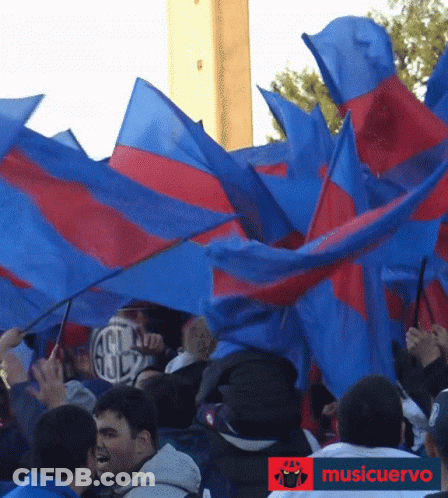 Crowd Waving Blue And Red Flags With Musicuervo Logo GIF