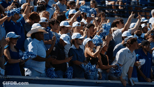 Crowd Wearing Pom Poms And Hats With Letter U GIF