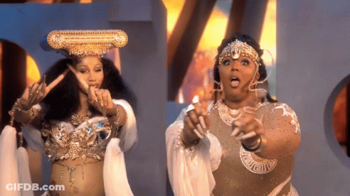Crowned Woman Next To Woman In Costume GIF
