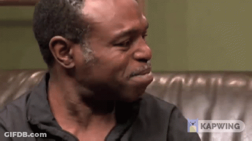 Crying Man Sitting On Couch With Kapwing Logo GIF