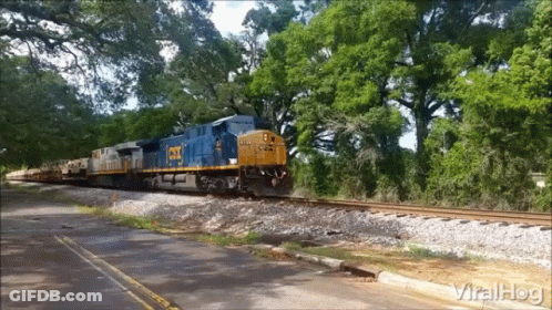 CSX Train Going Down Tracks Near Road GIF
