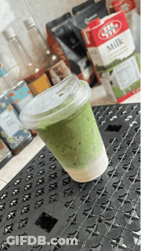 Cup Of Green Milk Next To JBT Milk Carton GIF
