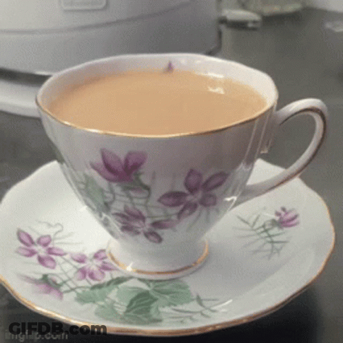 Cup Of Tea On Saucer With Purple Flowers GIF