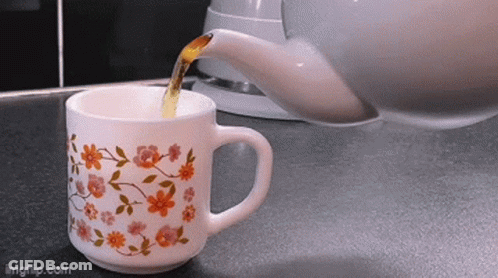 Cup Of Tea With Flowers Poured From Teapot GIF
