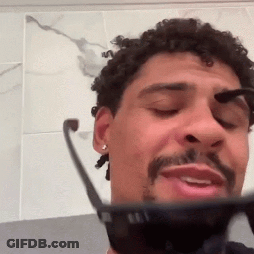 Curly Haired Bearded Man Brushing Eyebrows With Sunglasses GIF