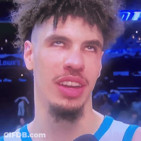 Curly-Haired Bearded Man In Blue-White Jersey On Mic GIF