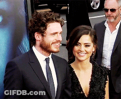 Curly Haired Bearded Man Smiling Next To Another Man GIF