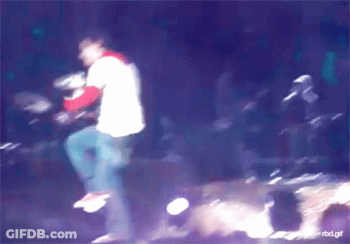 Curly-Haired Man Holding Microphone Smiling GIF