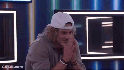 Curly-Haired Man In White Hat And Bracelets With Hands Folded GIF