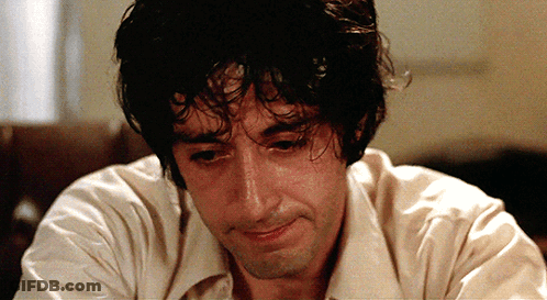 Curly Haired Man In White Shirt Looking Down GIF