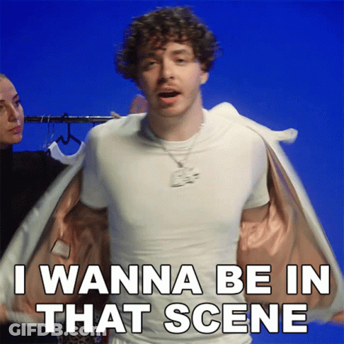Curly Haired Man In White T-Shirt And Jacket Says I Wanna Be In That Scene GIF