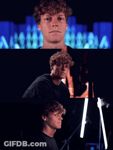 Curly-Haired Man Looking At Camera Dark Room GIF