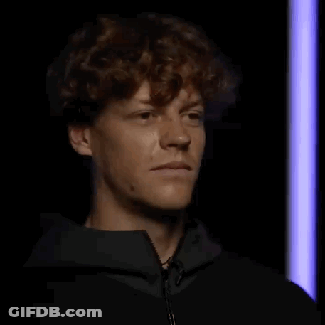 Curly-Haired Man Making Funny Face In Dark Room GIF